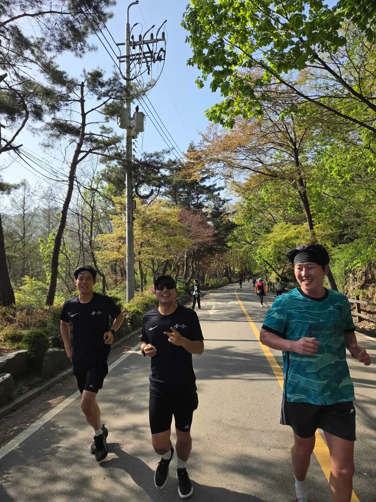 연둣빛 산길을 나란히 달리는 세 사람