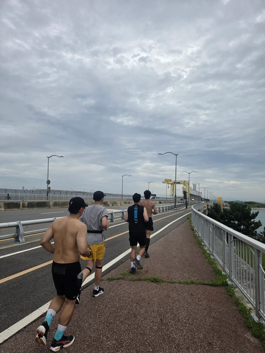 바다 옆 자전거길을 달리는 네 명